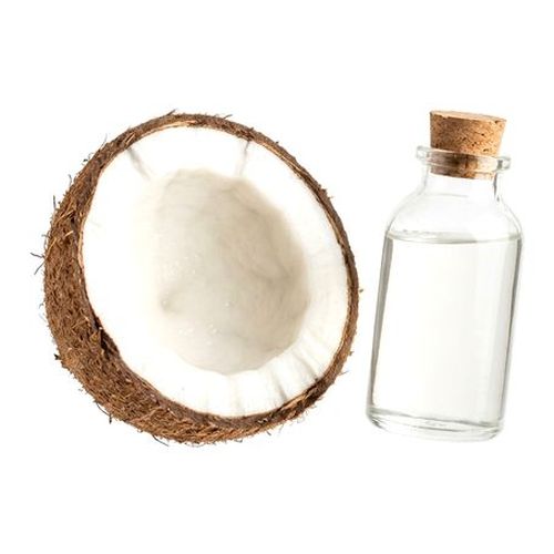 Coco aberto e frasco de óleo de coco